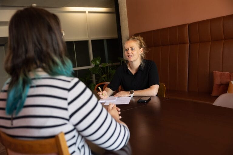 Op de foto voert een adviseur discriminatiezaken een gesprek met een melder. De melder is anoniem afgebeeld.