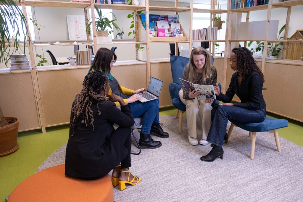 Op de foto zitten vier vrouwen op het kantoor van Tûmba.