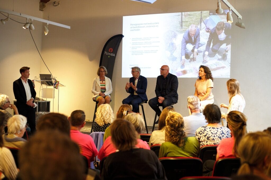 Vier sprekers op het podium tijdens een panelgesprek onder leiding van Sipke Jan Bousema tijdens het eerste symposium van de Regenboogalliantie, over een veilige en inclusieve werkvloer.