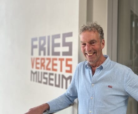 Mienskipsman Aad van der Burg poseert voor het logo van het Fries Verzetsmuseum