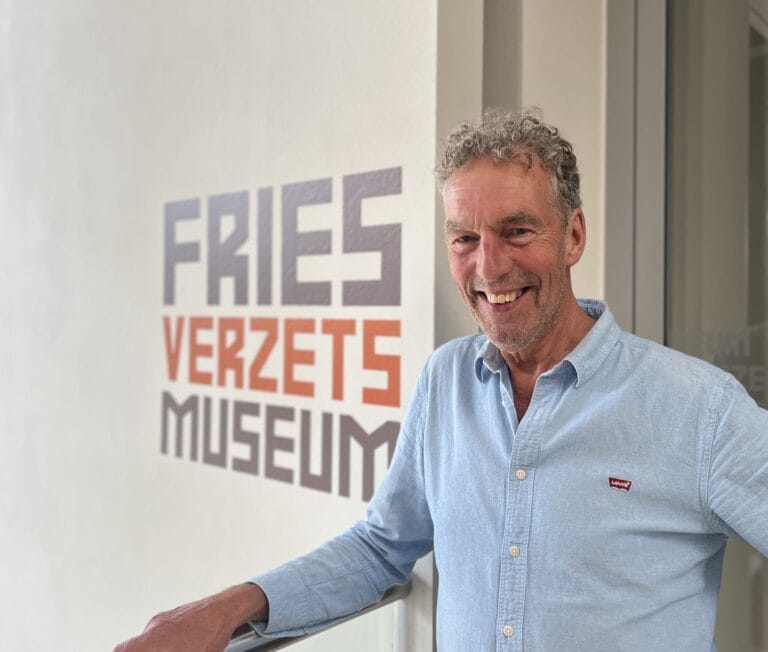 Mienskipsman Aad van der Burg poseert voor het logo van het Fries Verzetsmuseum