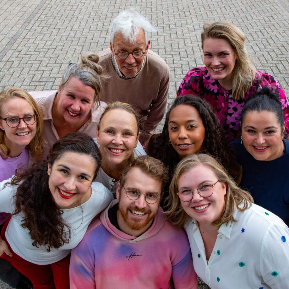 Teamfoto van de medewerkers van Tûmba met de hoofden dicht bij elkaar en de foto is van boven genomen.