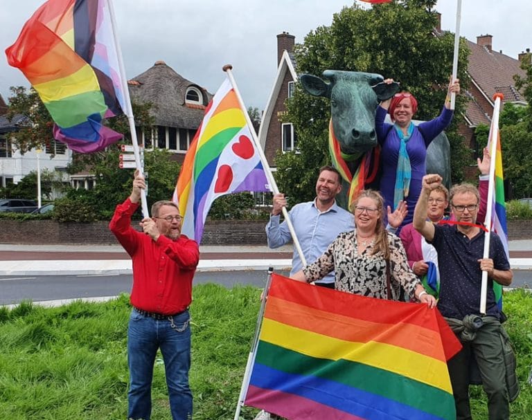 De Vaders en Moeders van kleurrijk Fryslân zwaaien met Pride en Fryslân-Pride vlaggen op de rotonde bij Ús Mem in Leeuwarden