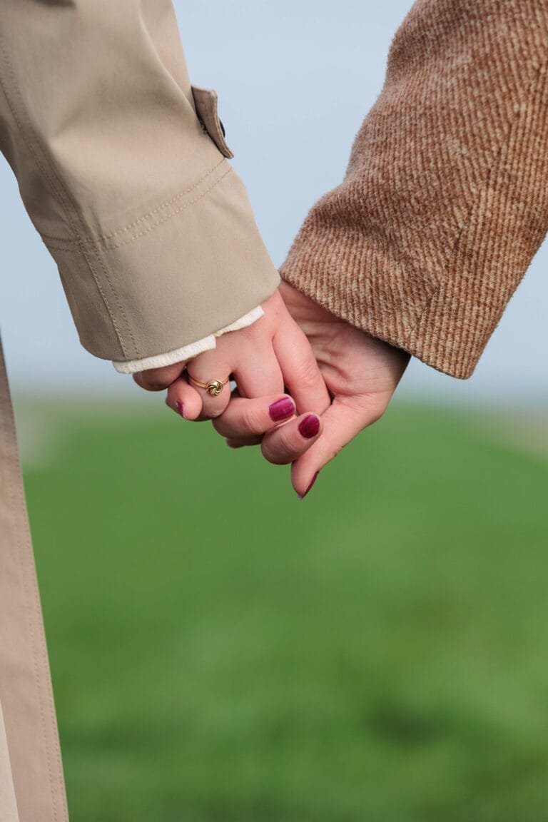 Een foto van twee vrouwenhanden hand in hand op Paarse Vrijdag