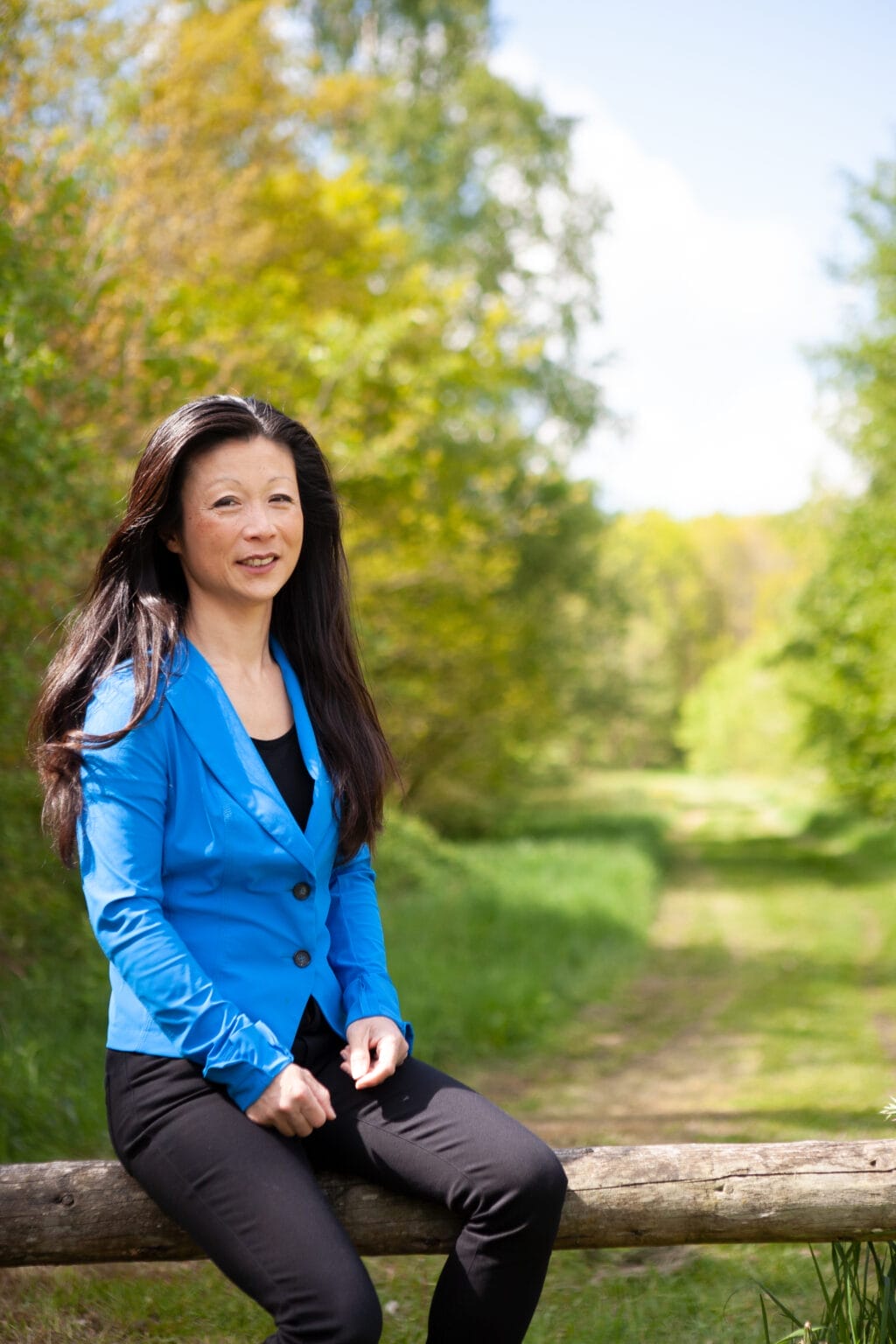 Foto van collega Jolanda Bergsma zittend op een hek in de natuur