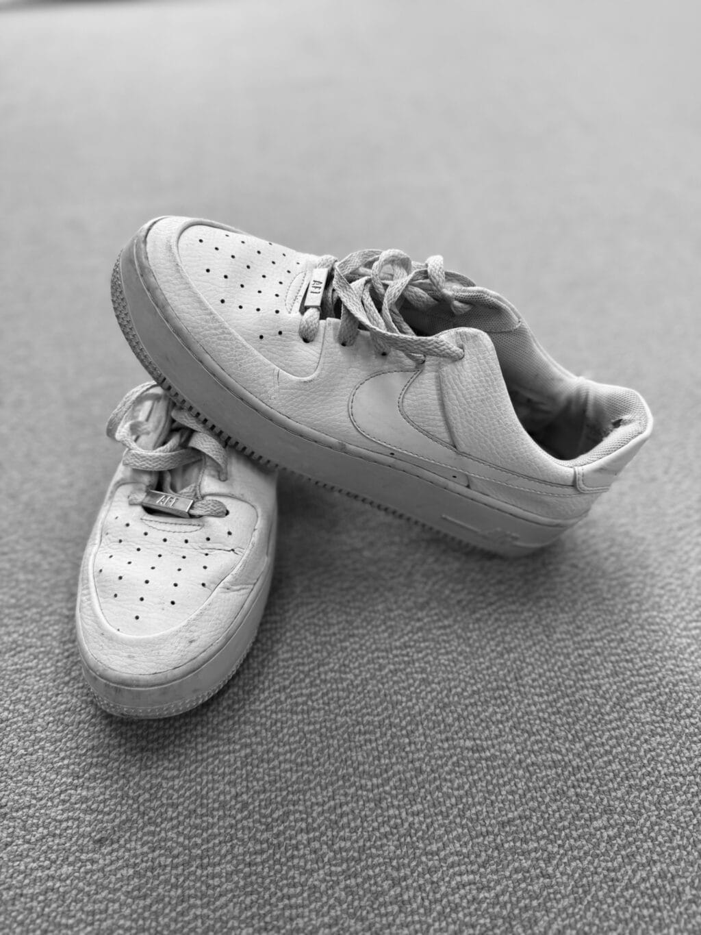 Een foto met daarop witte Nike Air Force 1. Om uit te beelden dat elk paar schoenen een verhaal heeft van een persoon die hierin heeft gestaan.